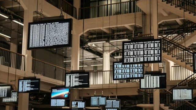 Monitors showing data hanging in a multi-storey hall