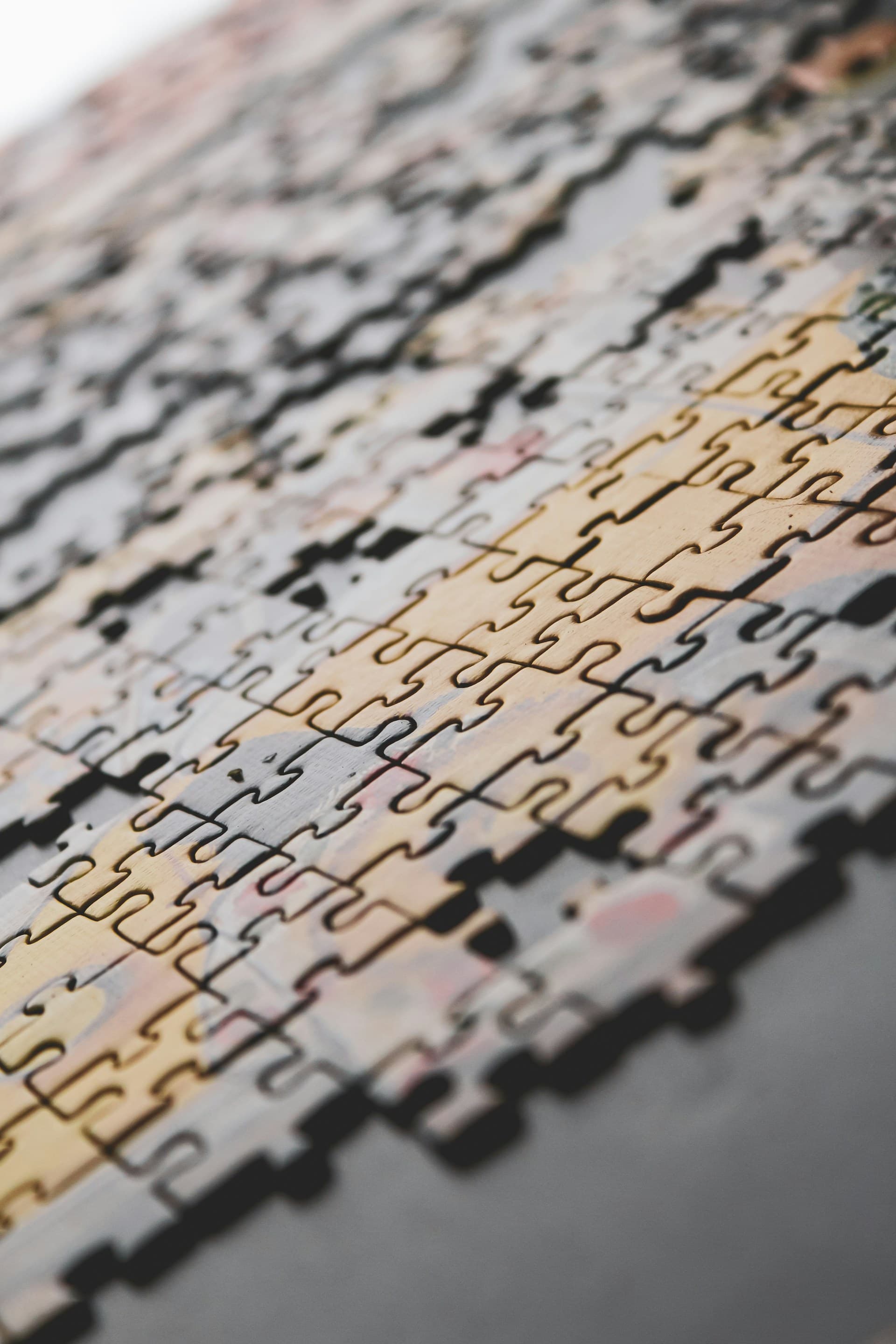 Four hands assembling coloured puzzle pieces